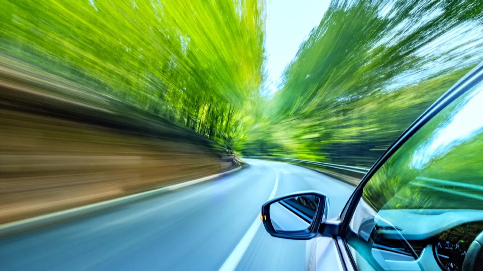 TISAX: Fahrendes Auto auf einer Landstraße aus Fahrerperspektive – Sinnbild für Informationssicherheit in der Automobilbranche