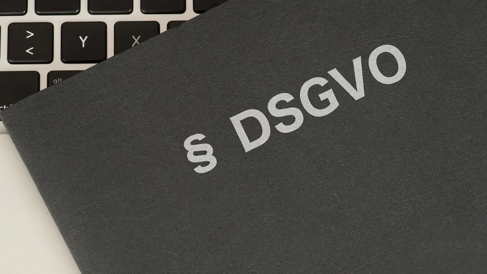 Broschüre „§ DSGVO" auf einer Laptop-Tastatur – Auftragsverarbeitungsvertrag und Datenschutz