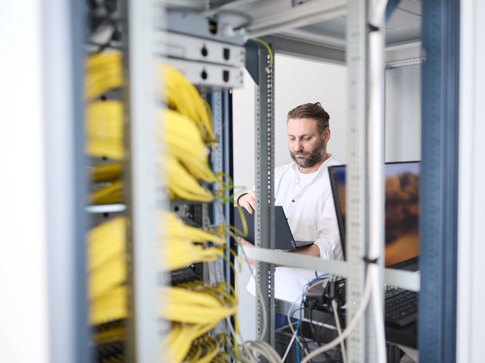 Infrastruktur: Techniker am Server-Rack mit Verkabelung
